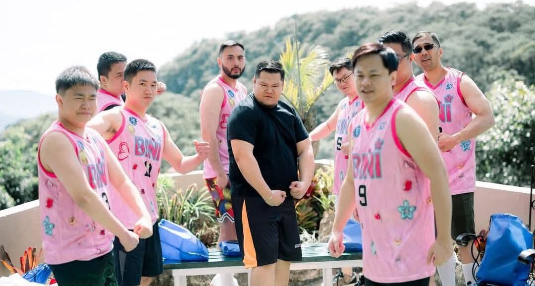 A group in matching pink jerseys at an outdoor event