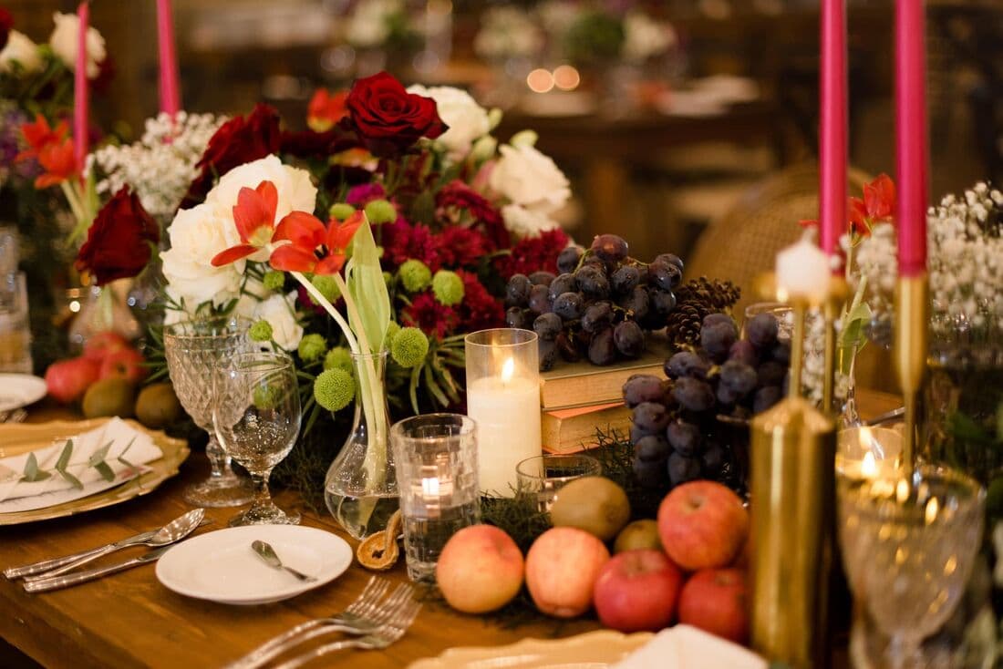A tablescape of fruit, candles and blooms