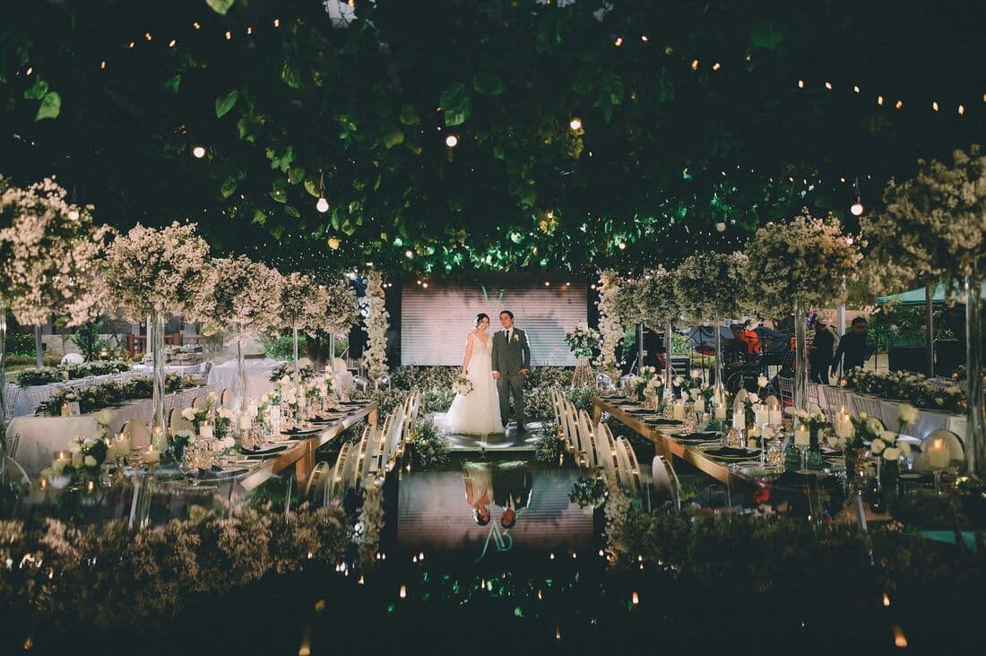 A garden reception strung with lights at dusk