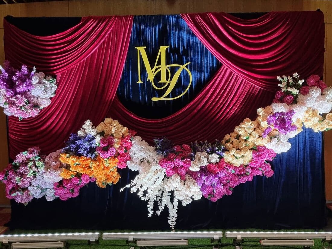 A monogrammed backdrop framed in flowers