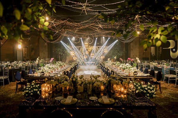 A long banquet table under a canopy of lights
