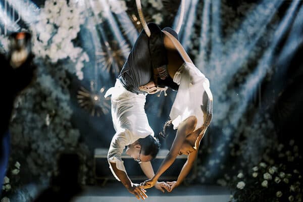 Aerial performers in white above the blooms