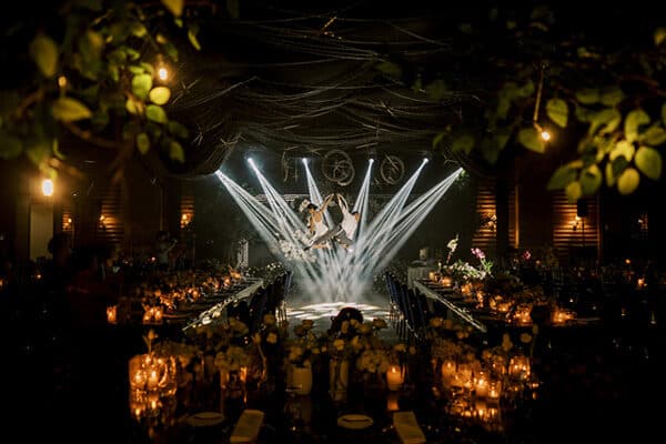 The couple in starburst light over a candlelit hall