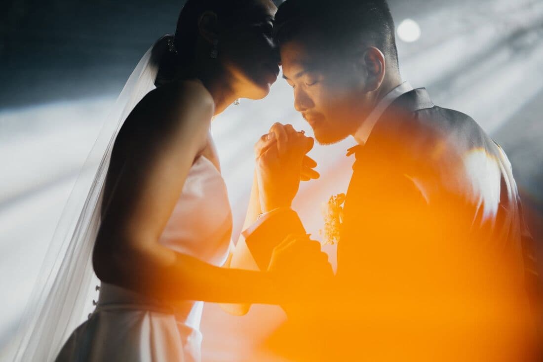 A couple embracing, seen through her veil in warm light