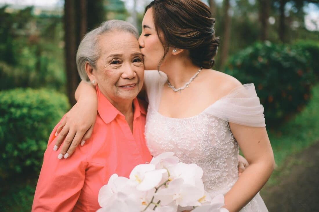 A bride kissing her grandmother on the cheek