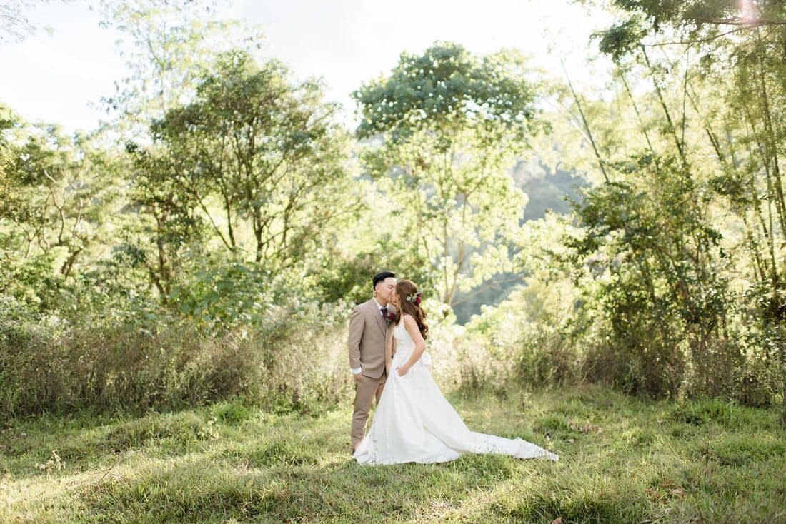 A bride walking through a sunlit forest clearing