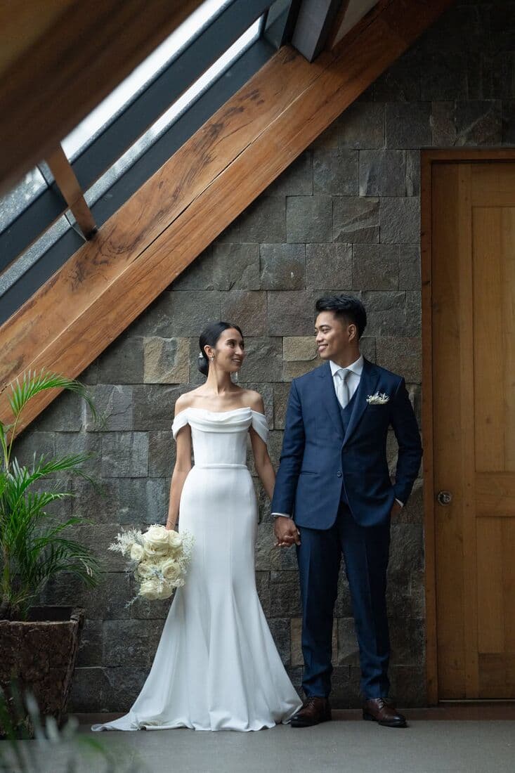 A couple standing against a stone wall