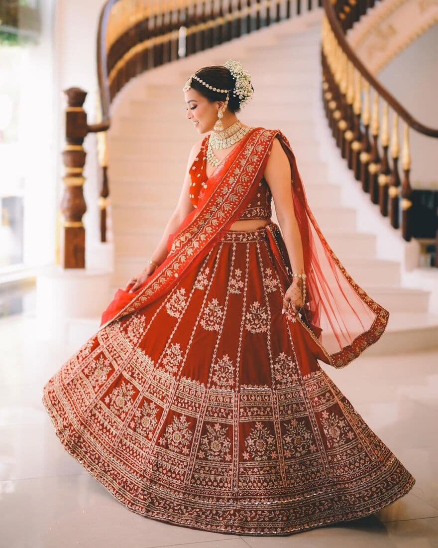 A bride on a staircase in a red lehenga