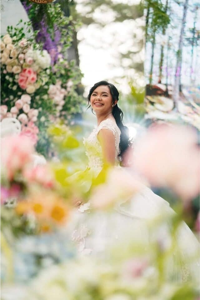 A bride seen through a screen of flowers