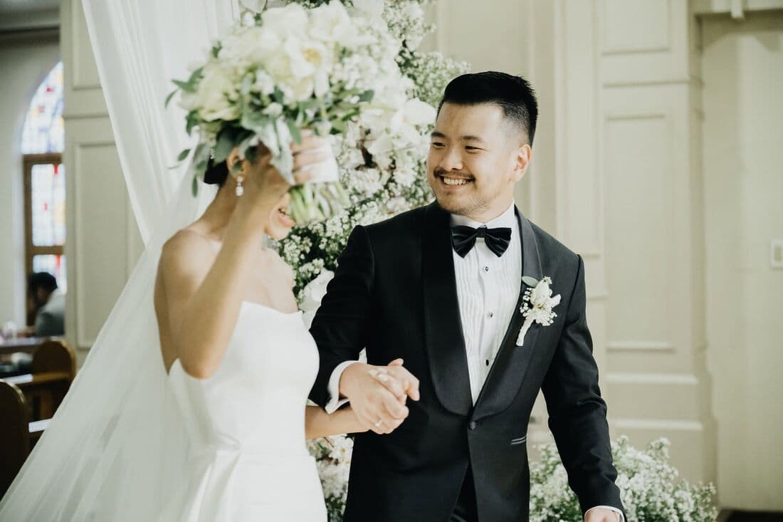 A couple in a doorway, the bride laughing