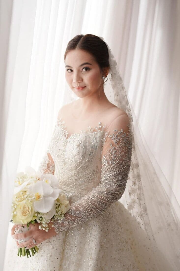 A bride at a window in a beaded gown