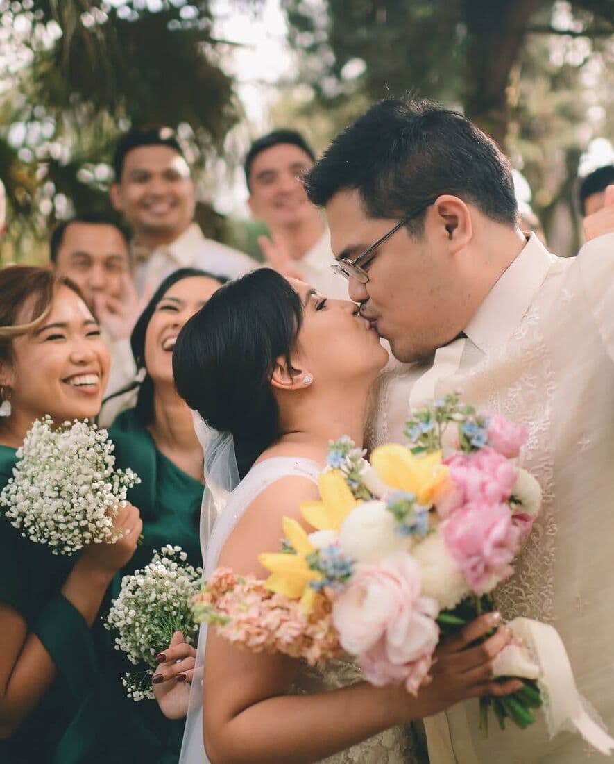 A couple kissing, surrounded by friends