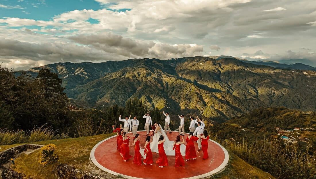 The bridal party on a red platform above the mountains