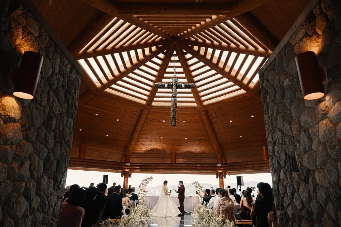 A ceremony beneath the timber ceiling of a stone chapel