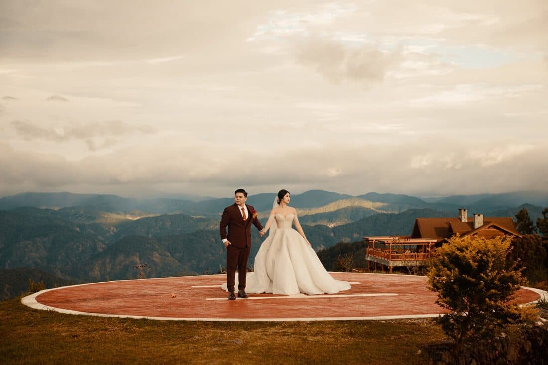 The couple alone on the platform, mountains behind