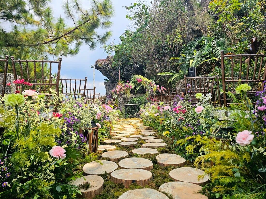 A garden path of stone rounds through the flowers